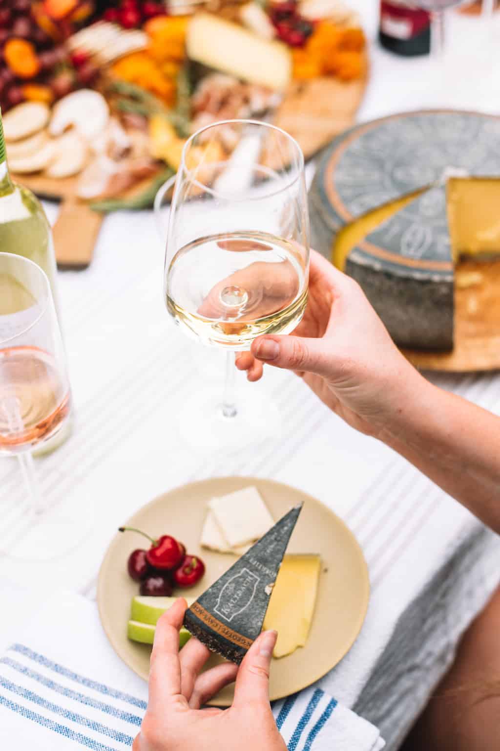 A person holding a glass of white wine.