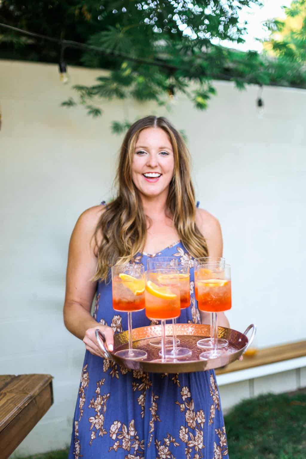 Holding a tray of aperol spritz outside. 