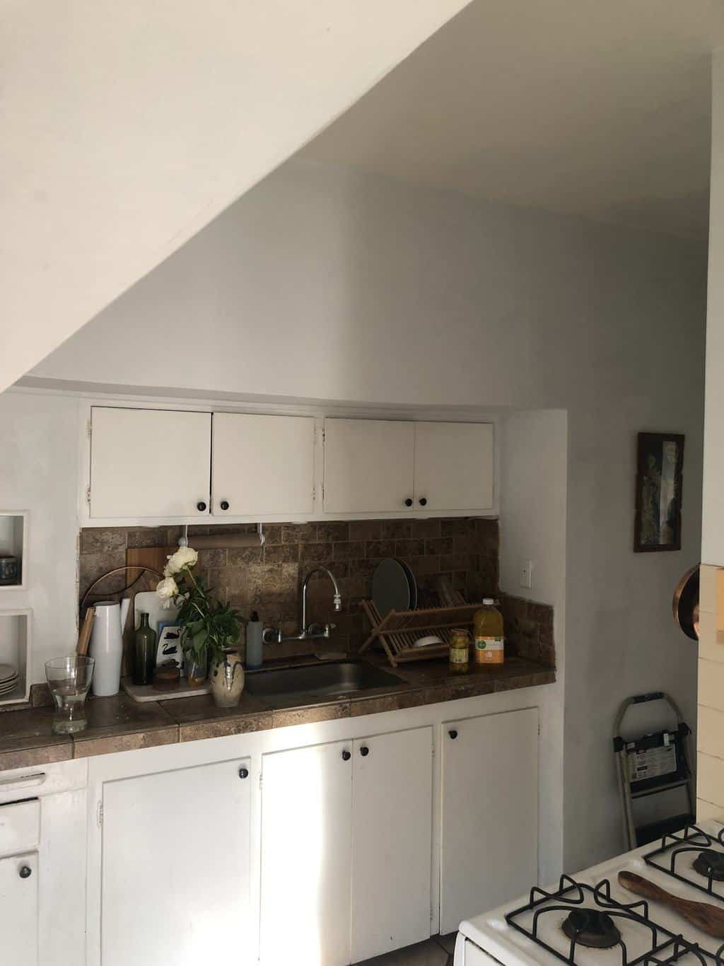 before photo with white cabinets and a silver sink. 