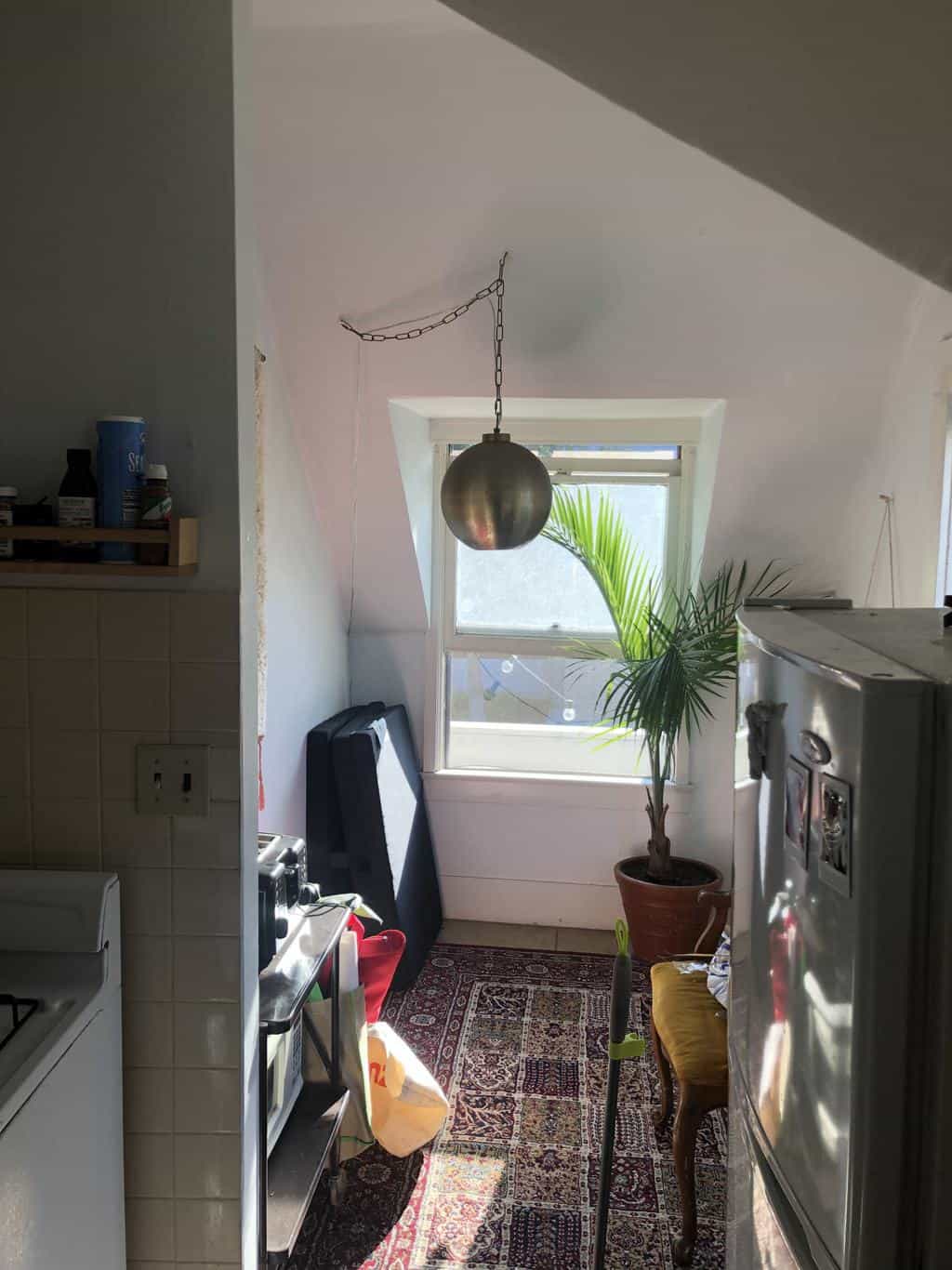 Small dinning room with no table and old light fixture. 