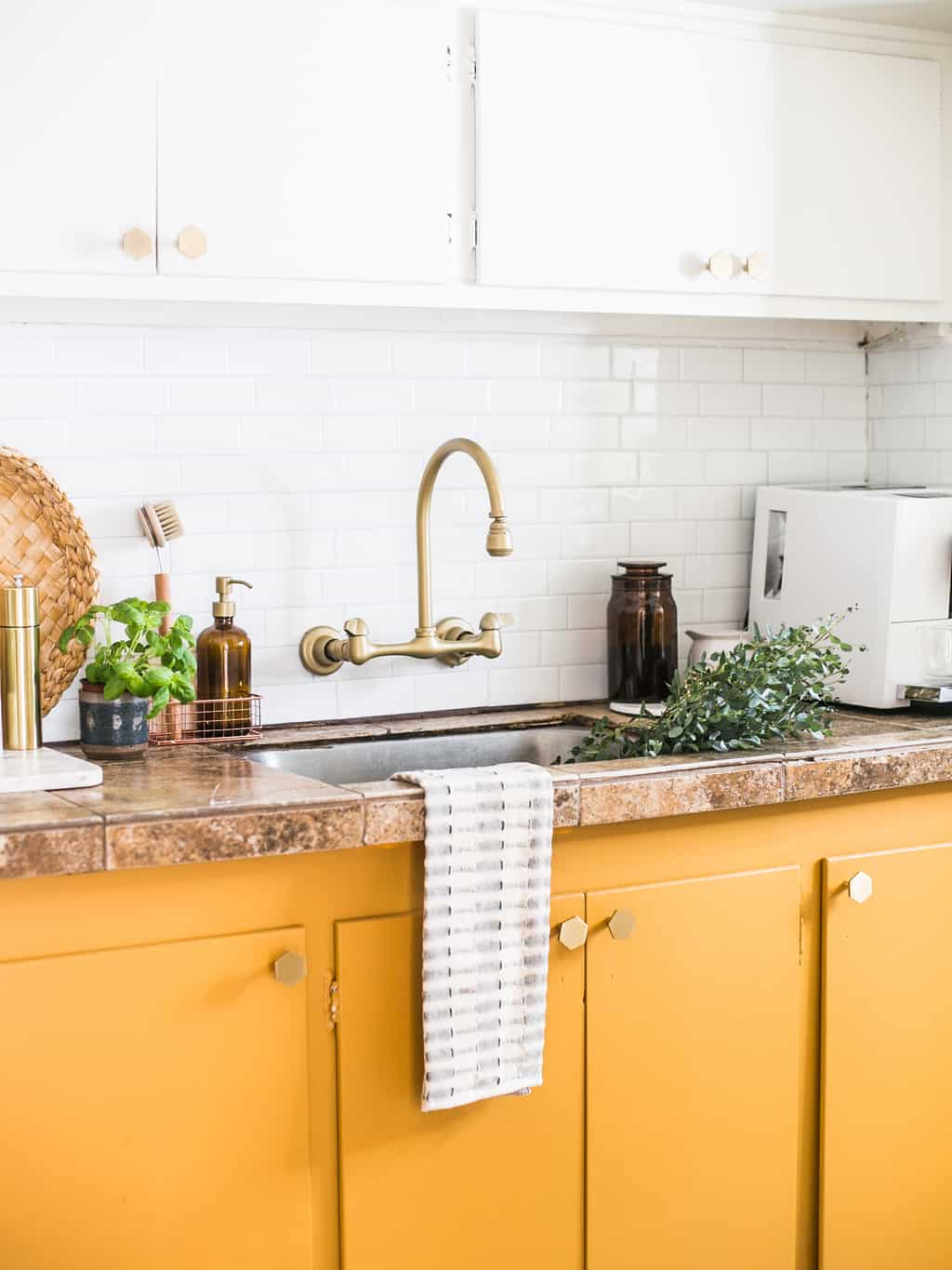 Mustard yellow cabinets with gold hardware.