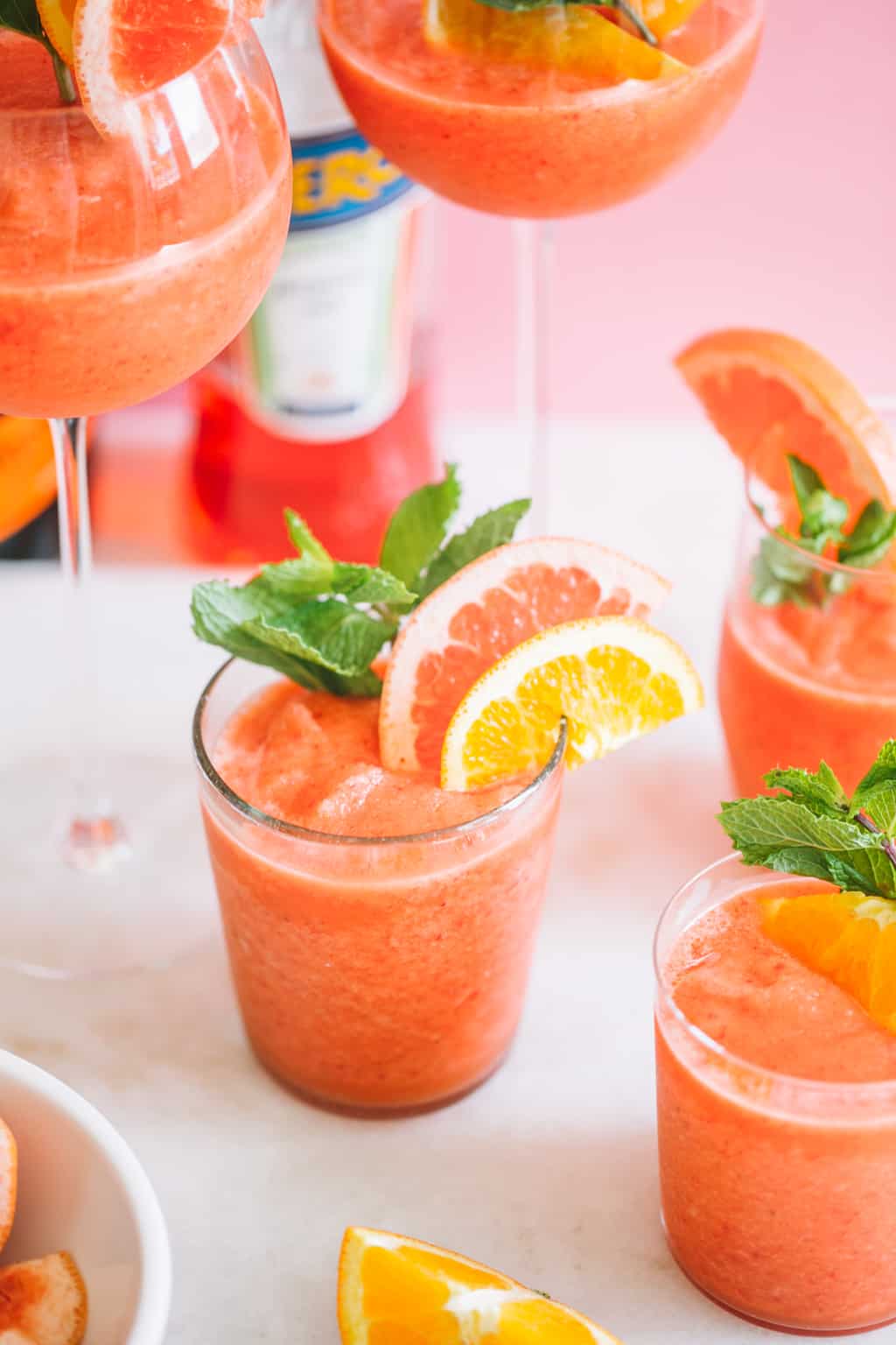 blended frozen cocktail with aperol in glasses with citrus slices and mint