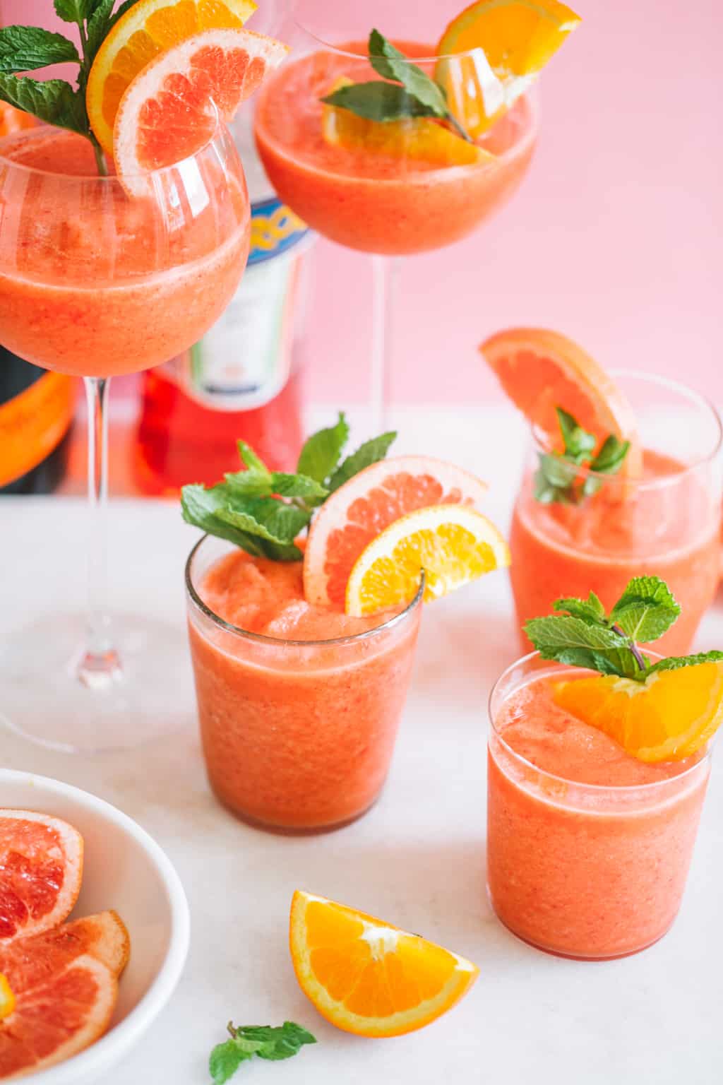 blended frozen cocktail with aperol in glasses with citrus slices and mint