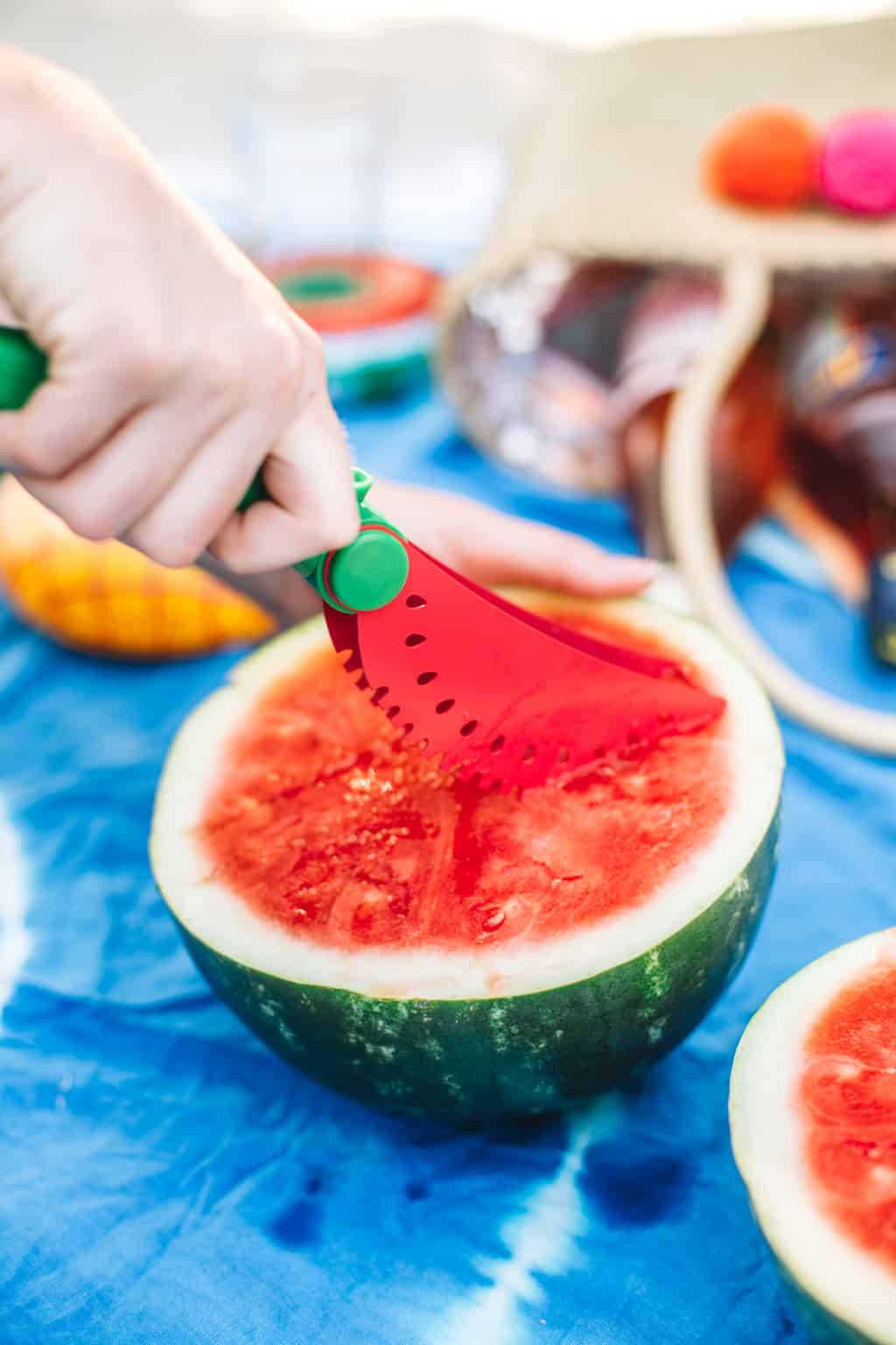 Watermelon slicer cutting into half of a watermelon. 