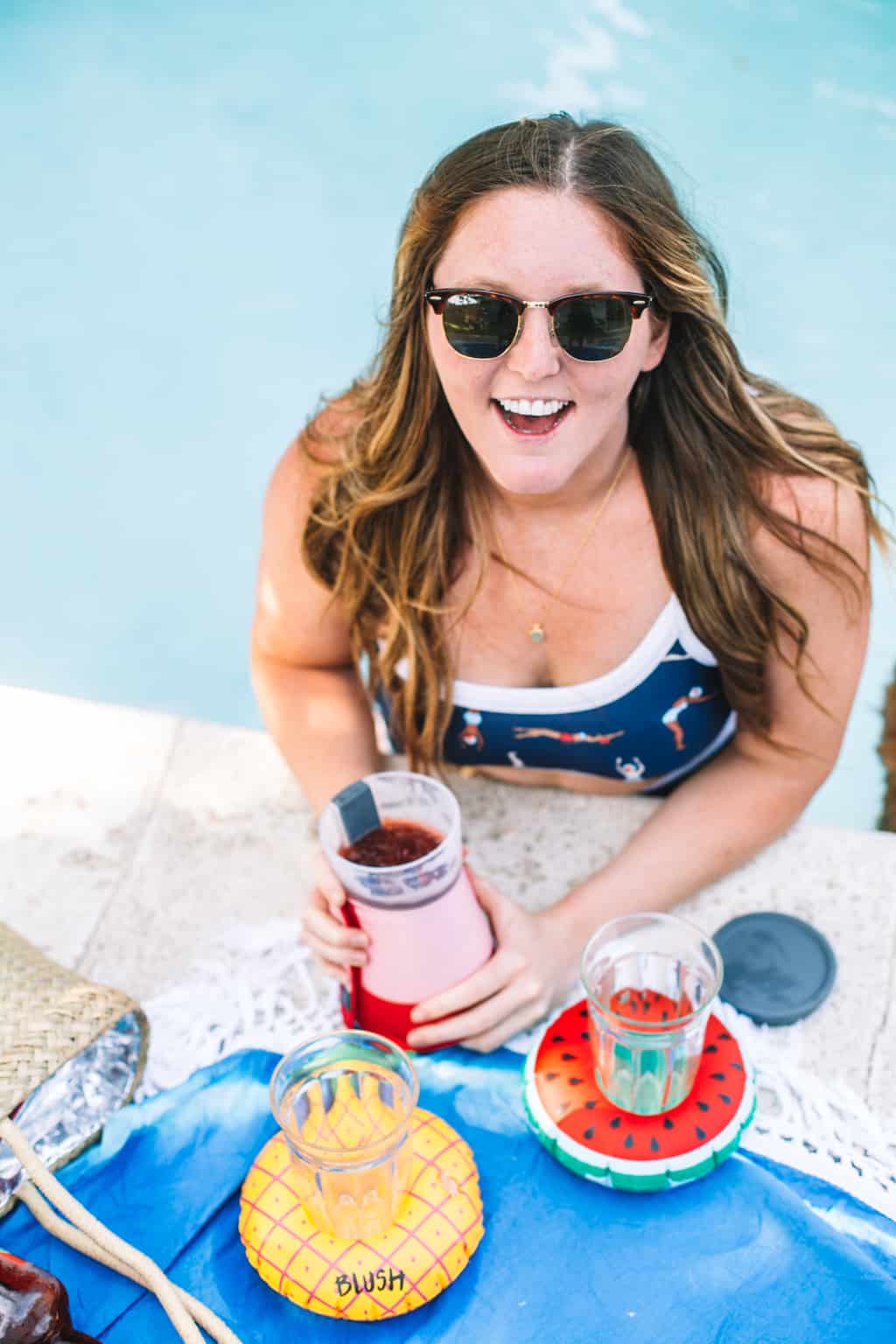 Girl in pool holding onto a frozen cocktail maker.