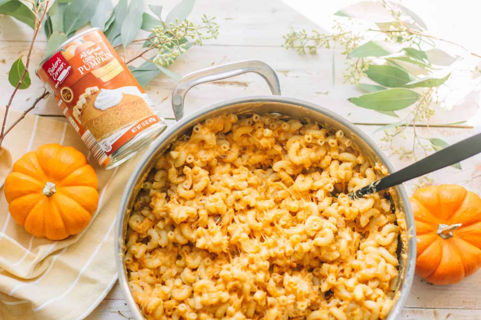 A pot of pumpkin mac and cheese being stirred.