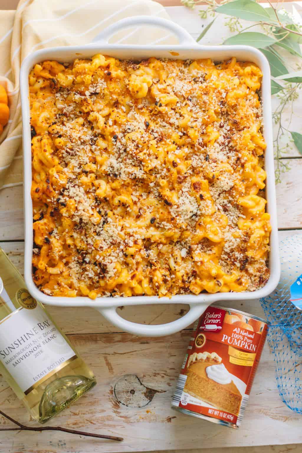 A platter of pumpkin mac and cheese in a white square casserole dish served with it's ingredients.