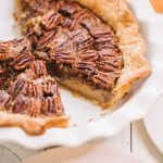 simple pecan pie recipe in white pie dish with two slices removed