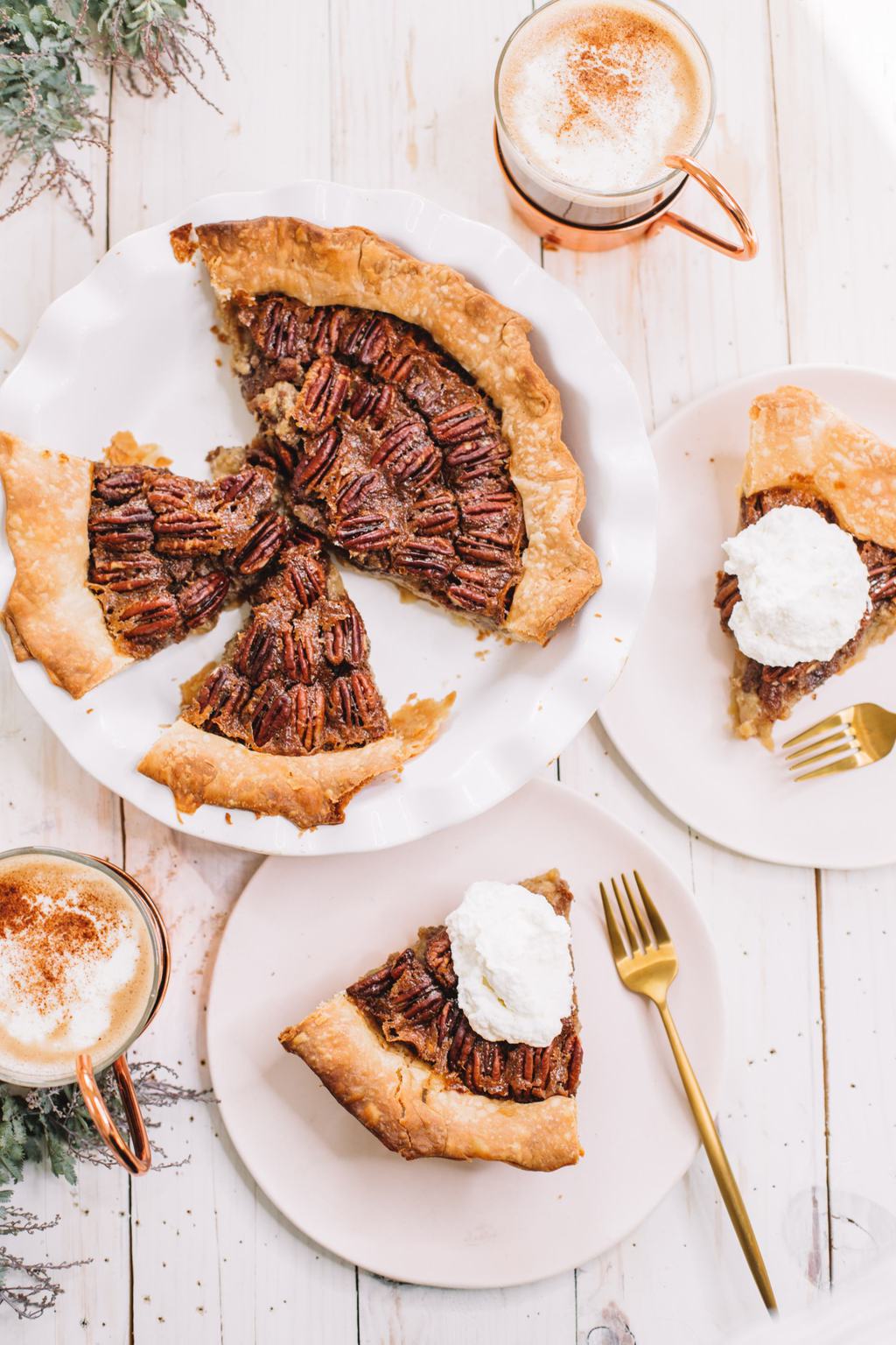 pecan pie recipe with brown sugar in white pie dish with two slices removed and on white plates with whipped cream