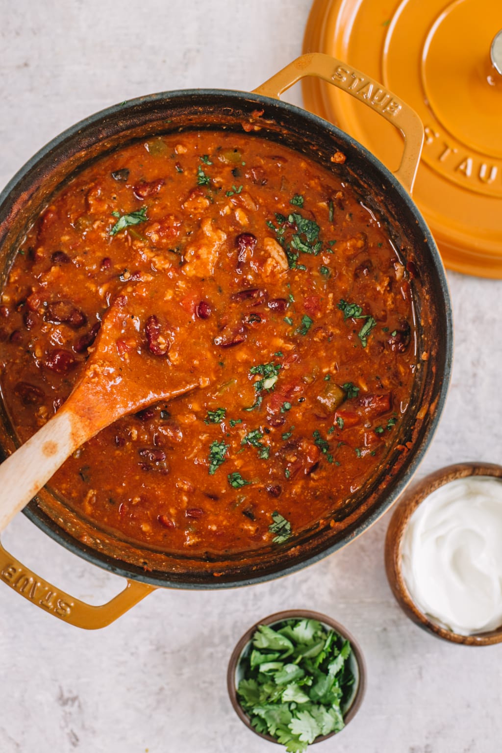 chipotle turkey chili recipe in yellow dutch oven with wooden spoon