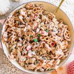 easy white chocolate snack mix recipe in large bowl with spoon and Christmas ribbon