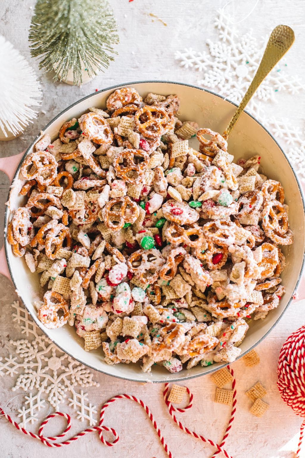 easy white chocolate snack mix recipe in large bowl with spoon and Christmas ribbon