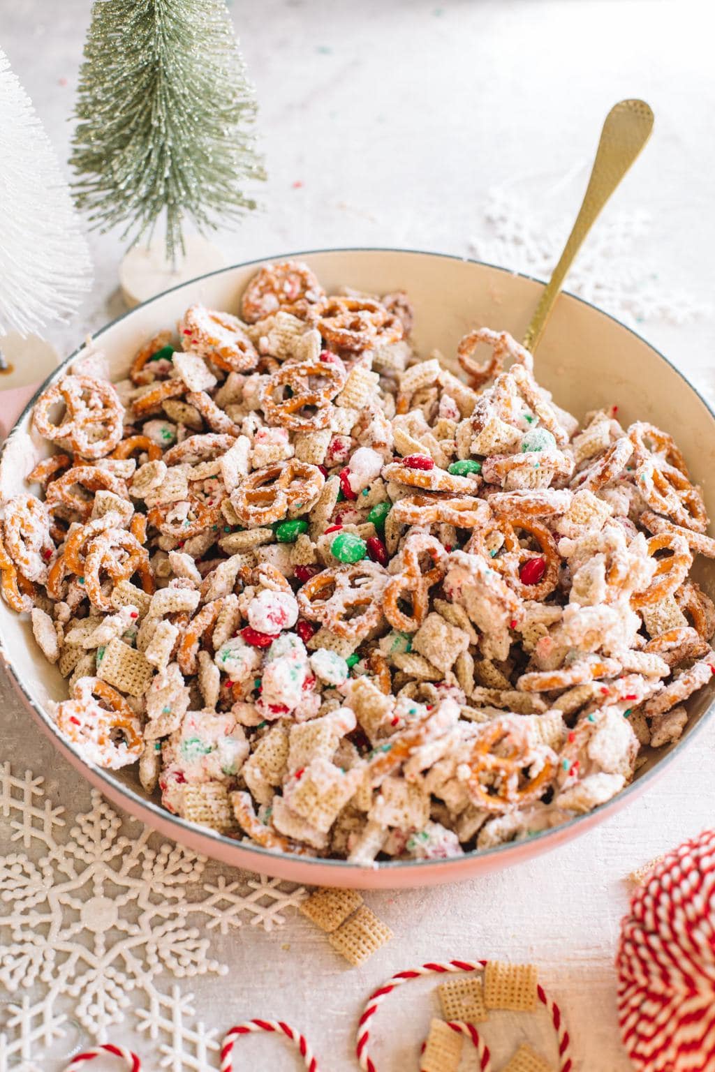 easy white chocolate snack mix recipe in large bowl with spoon and Christmas ribbon