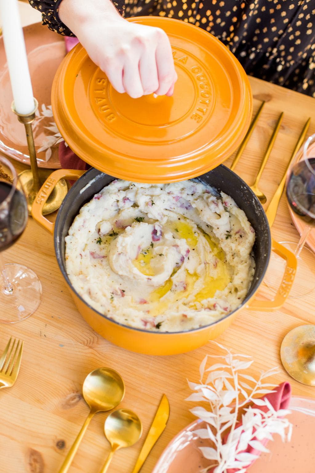 Mustard yellow dutch oven with mashed potatoes inside. 