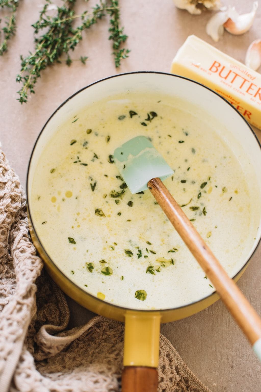 melted butter, cream, garlic and thyme in small saucepot with spatula for mashed potatoes