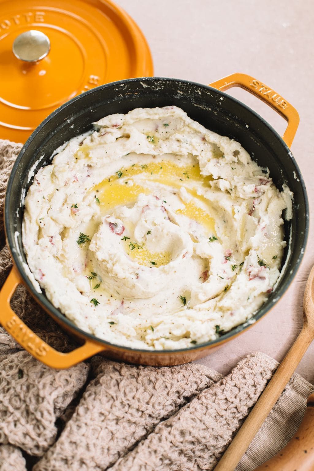 easy garlic mashed red potatoes in yellow dutch oven with melted butter on top