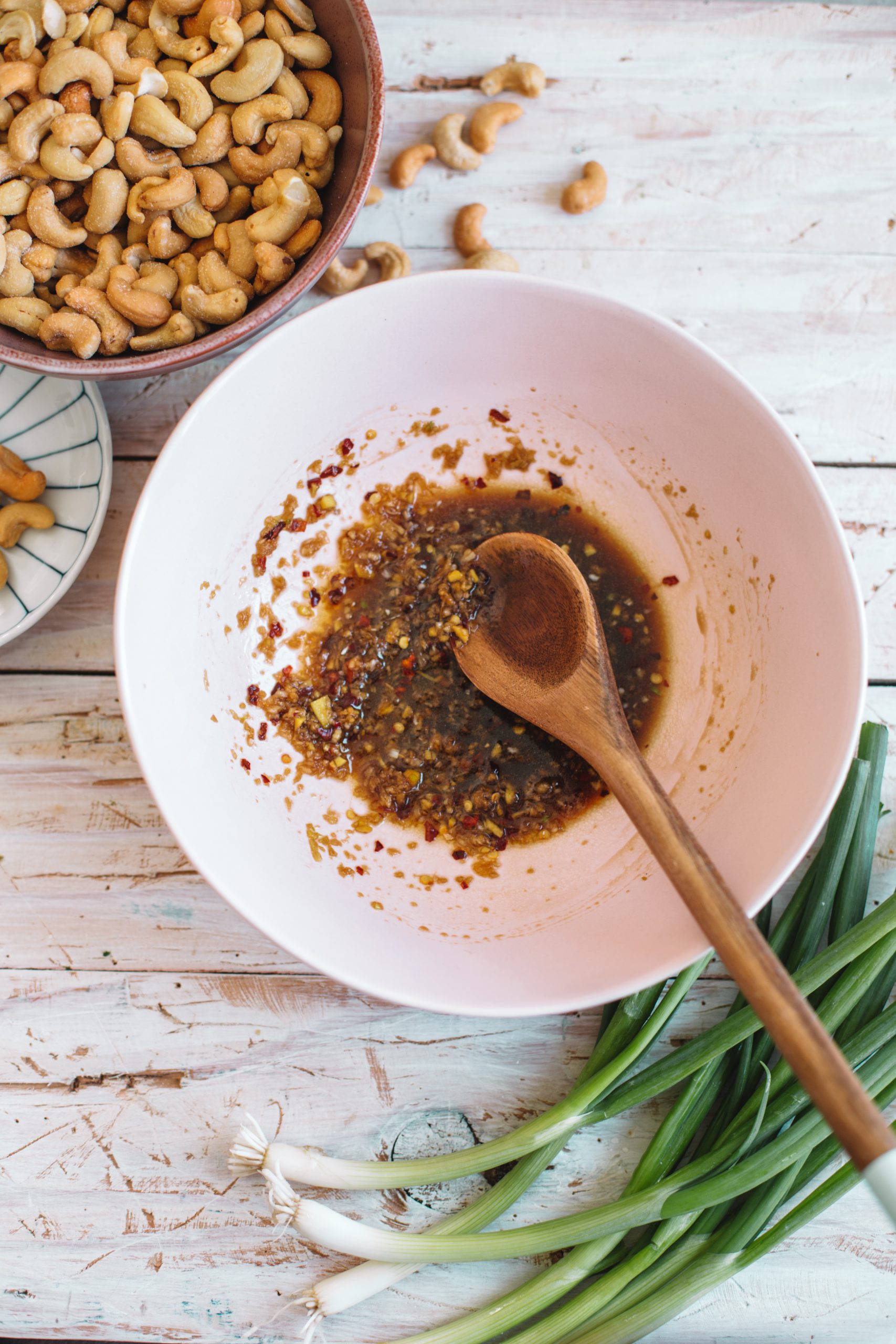 Pink bowl filled with marinade for cashew chicken.