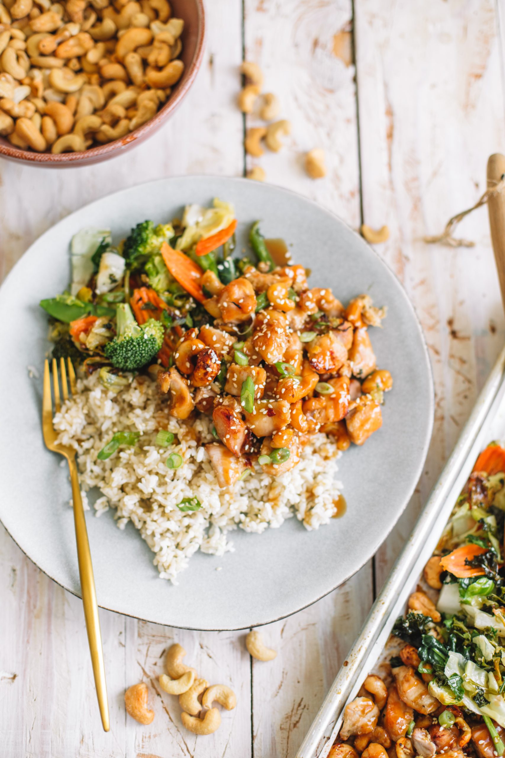 Blue plate of cashew chicken, vegetables and brown rice.