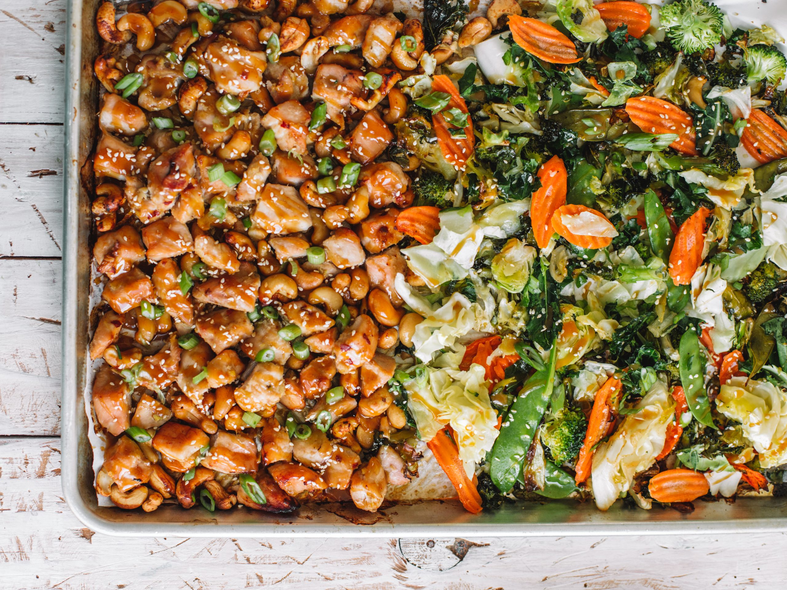 Sheet pan baking tray of cashew chicken and asian vegetables.