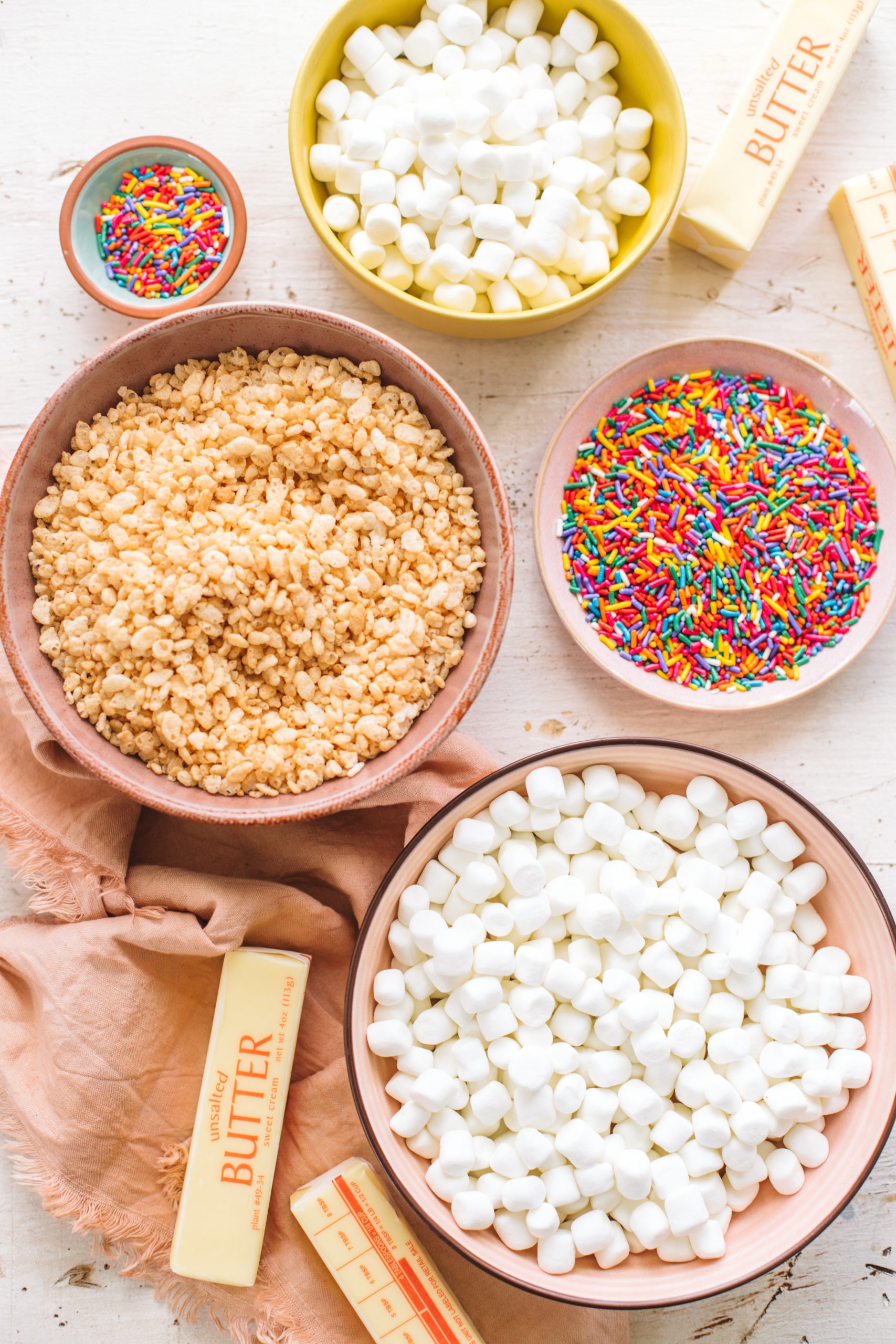 Bowls of marshmallows, rice krispies, sprinkles and butter.