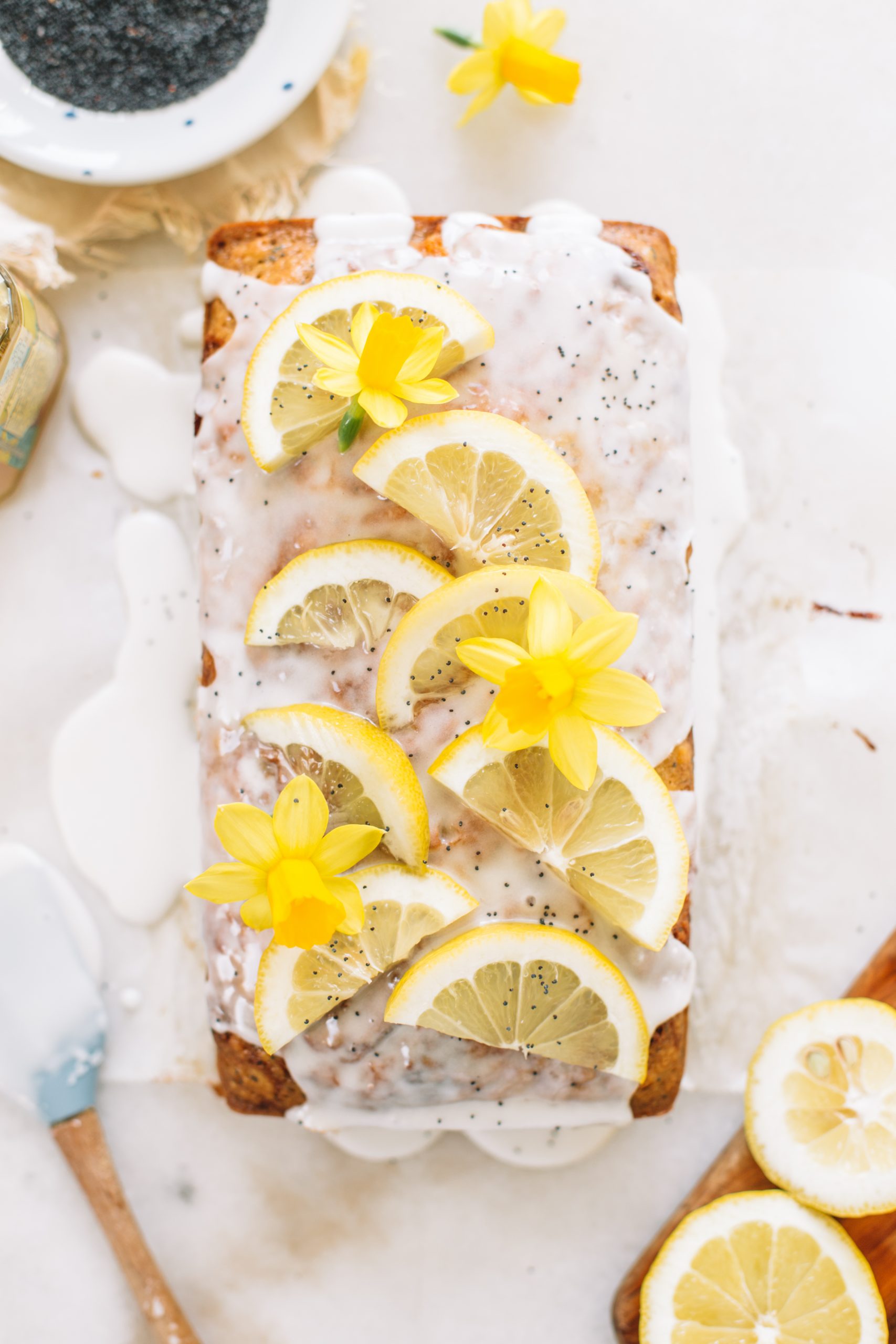 Lemon poppyseed loaf cake topped with lemon slices and poppy seeds. 