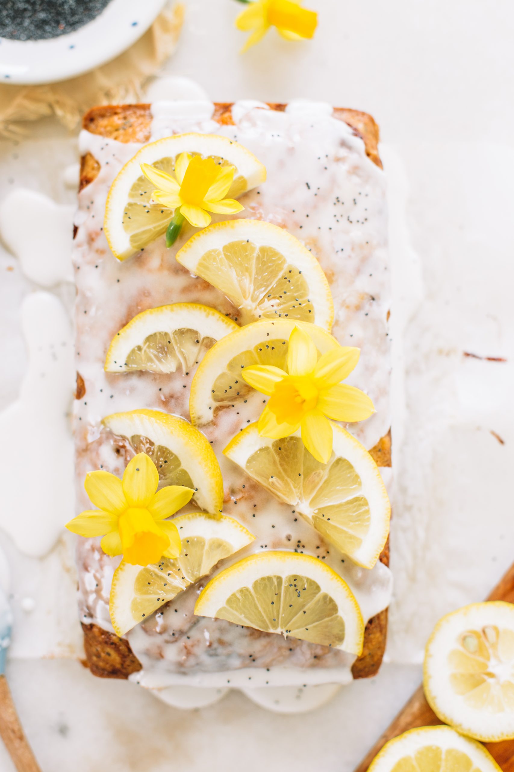 a lemon poppy seed loaf with icing and lemon slices as garnish
