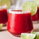 frozen strawberry margarita blended cocktail in glass with salt rim and lime wheel