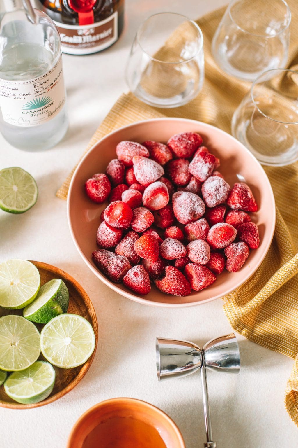 tequila, frozen strawberries, limes, jigger, glasses