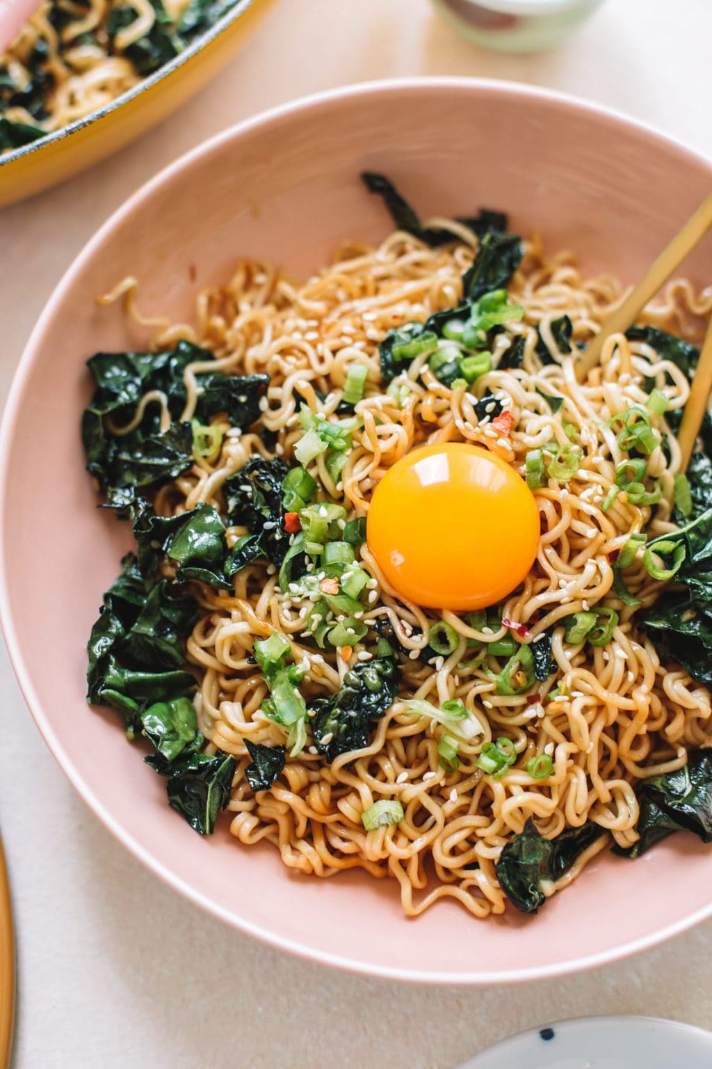 Garlic Butter Ramen Noodle Stir Fry served in a pink bowl with golden chopsticks. 