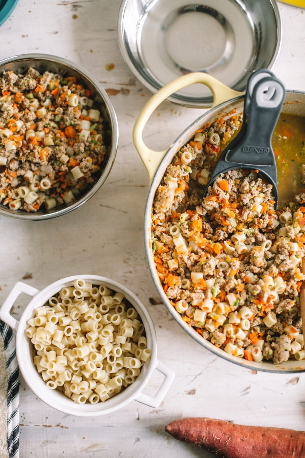 scooping out all natural dog food into bowls from dutch oven