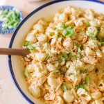 Hawaiian macaroni salad served in a white serving dish with a blue rim.