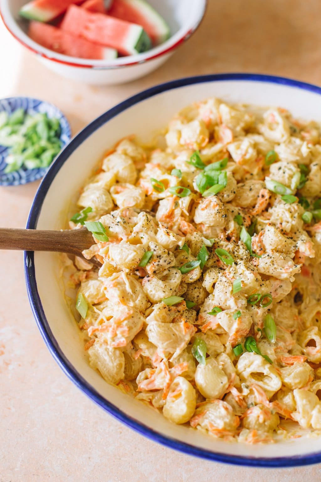 Hawaiian macaroni salad served in a white serving dish with a blue rim. 