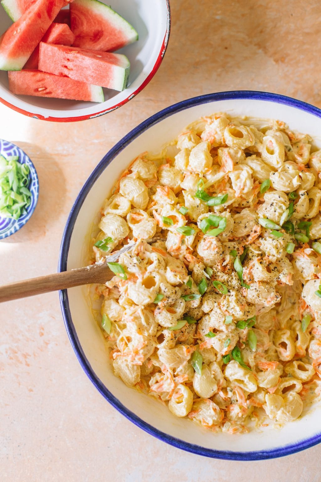 Hawaiian macaroni salad served in a white serving dish with a blue rim. 