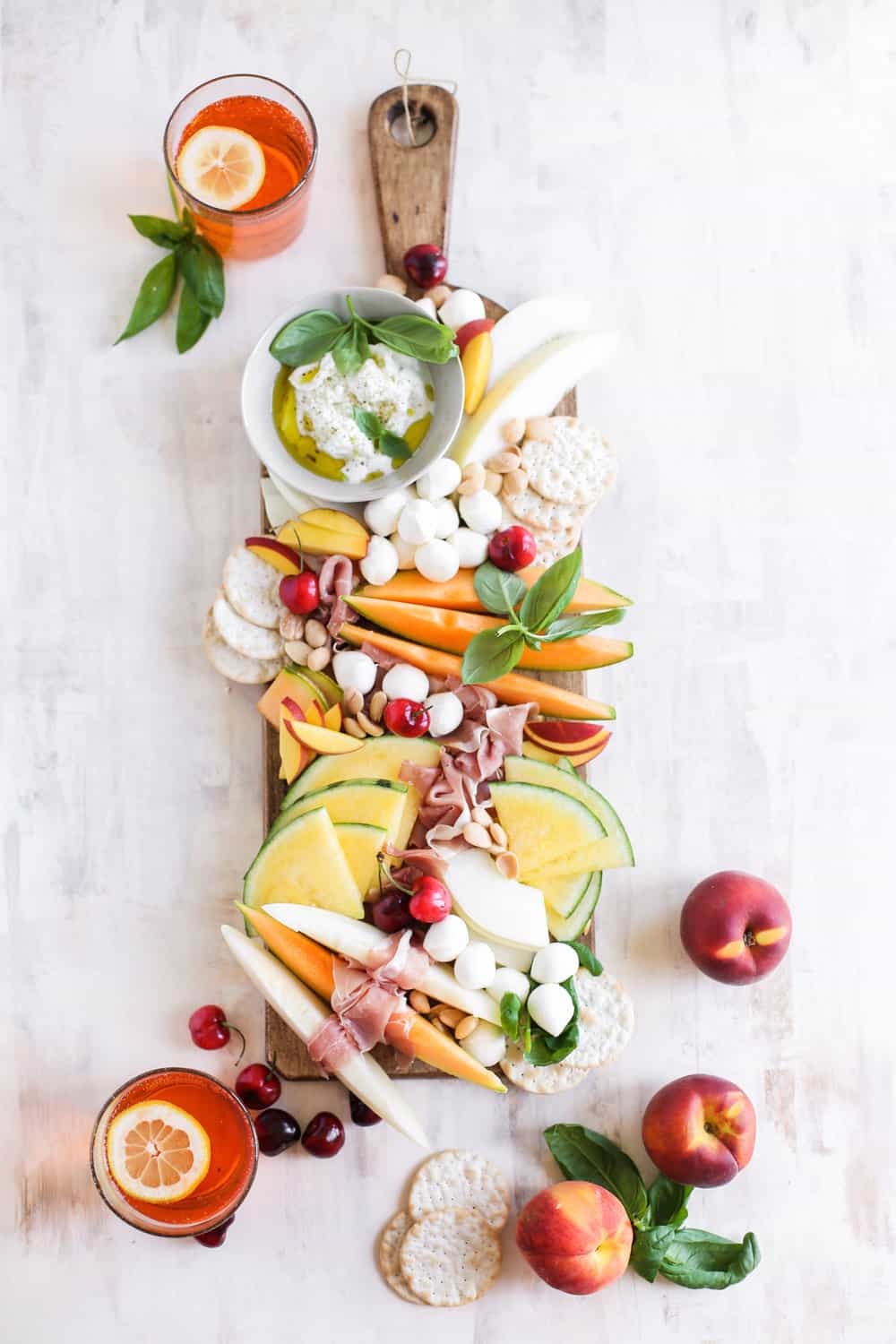 A long cheeseboard filled with a variety of Italian melons, prosciutto and mozzarella. 