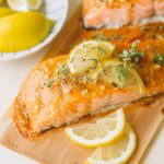 glazed salmon fillets with lemon slices and fresh thyme on cedar plank