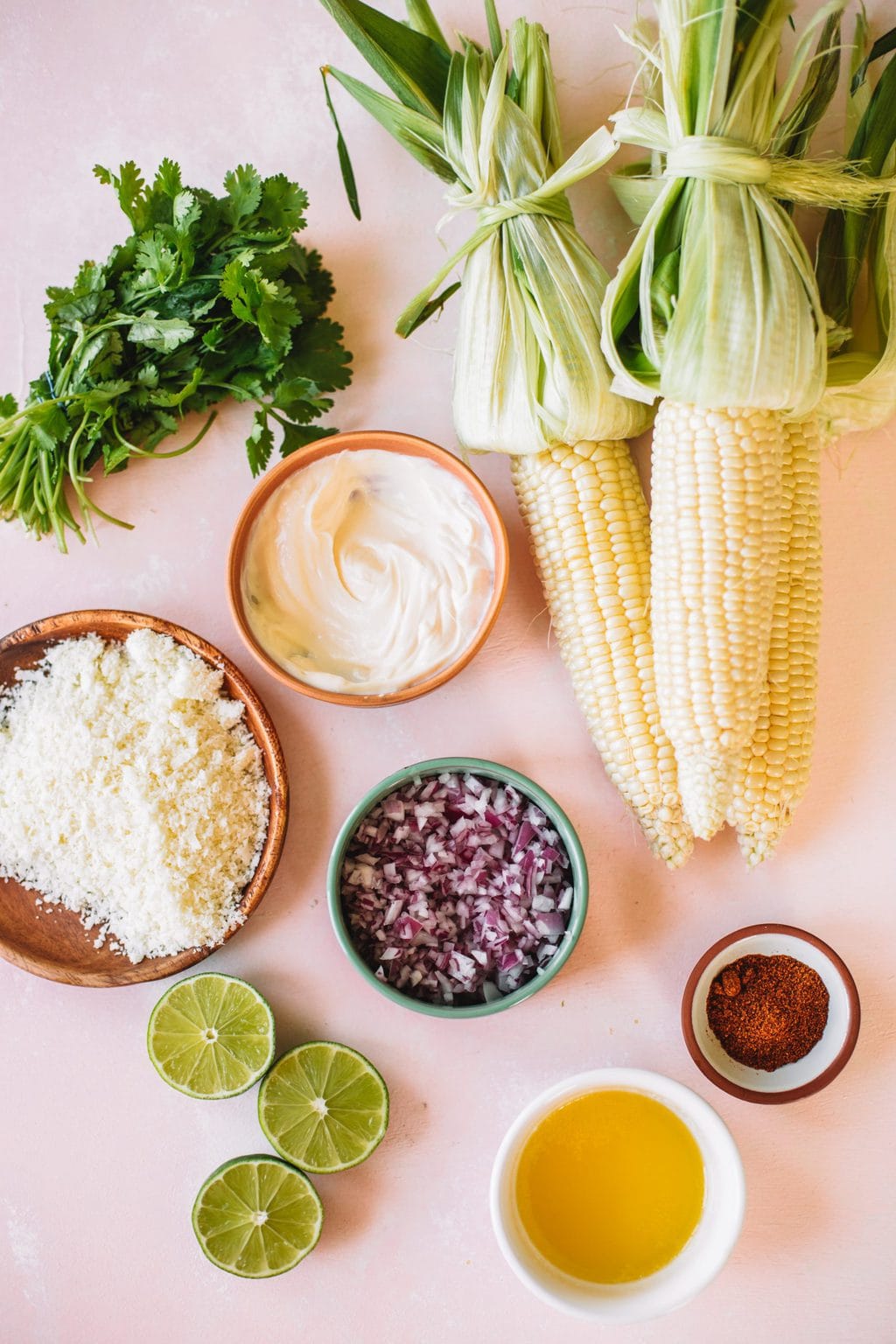 Cotija cheese, mayonnaise, red onion, limes, corn, chili powder, and melted butter.