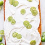 A rectangle sheet pan key lime cake with frosting and key lime wheels.