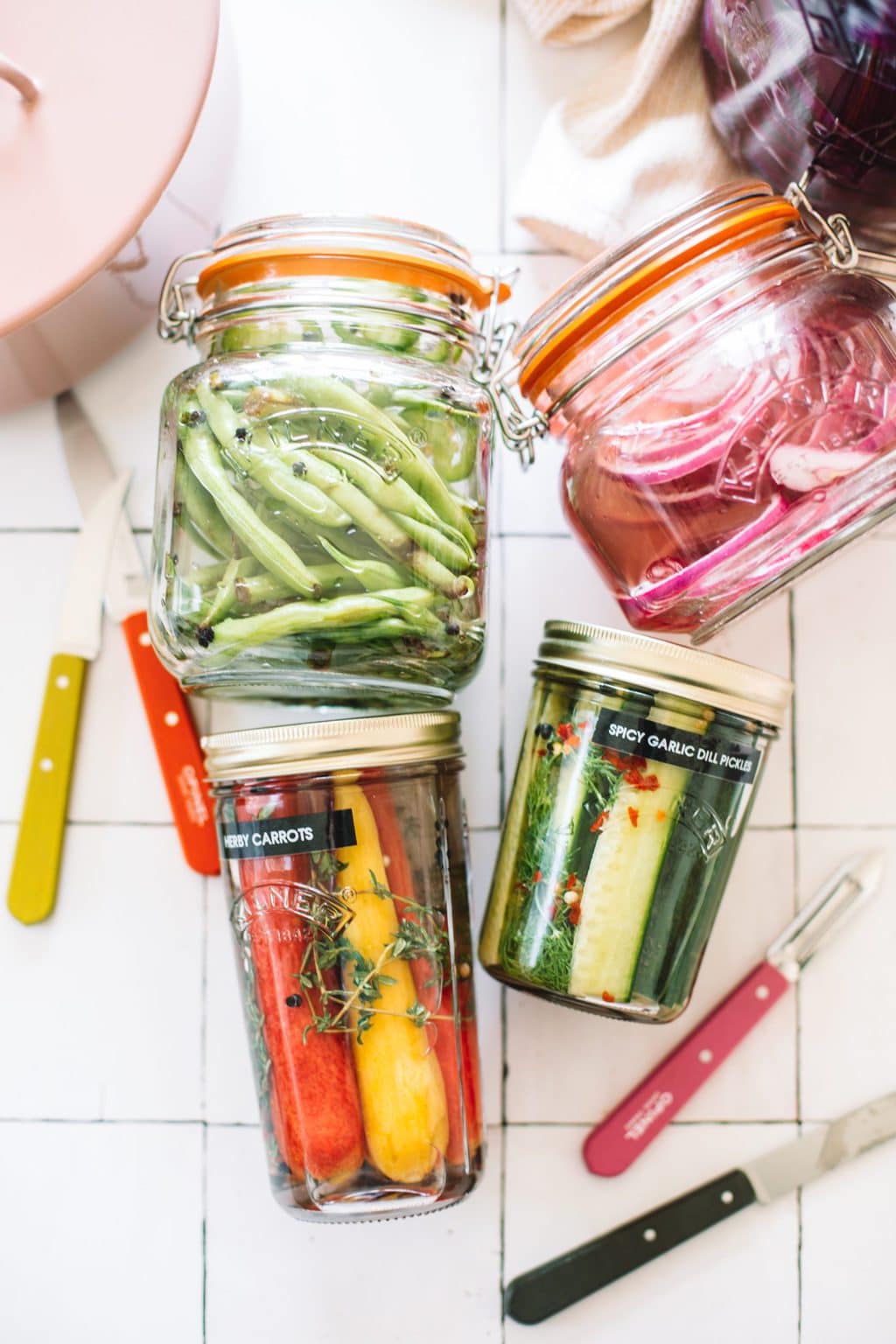 pickled green beans, red onions, carrots and cucumbers in glass jars