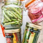 pickled green beans, red onions, carrots and cucumbers in glass jars