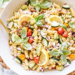 easy pasta salad with beans, avocado, cucumbers, tomatoes, basil in white bowl