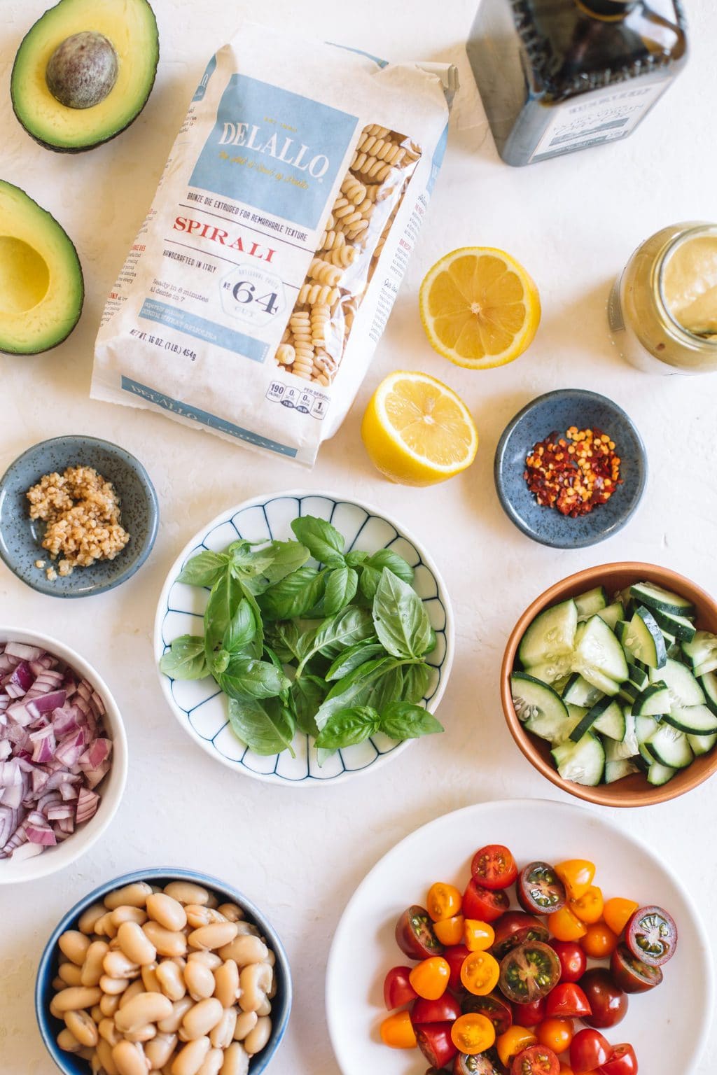 pasta package, avocado, halved lemon, basil, diced onions, cucumbers 