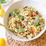 vegan pasta salad with cucumbers, tomatoes, basil in white bowl