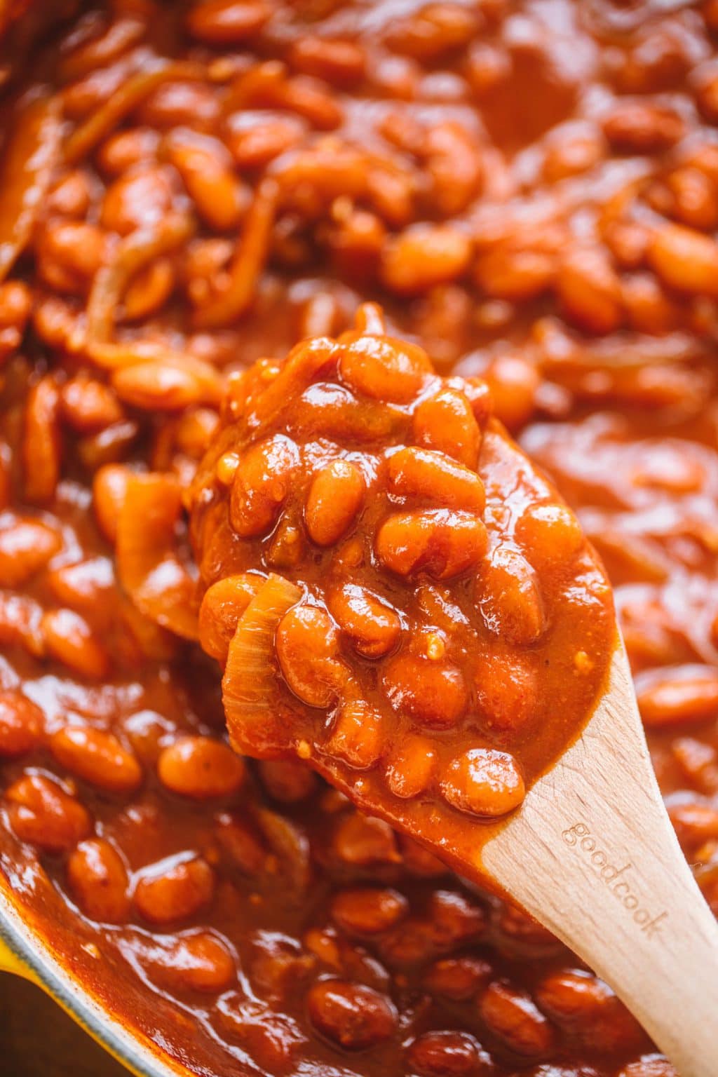 homemade baked beans in pot with wooden spoon