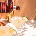 hand pouring grand marnier floater on top of cadillac margarita