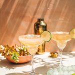 two top-shelf tequila margaritas in glasses with cocktail shaker