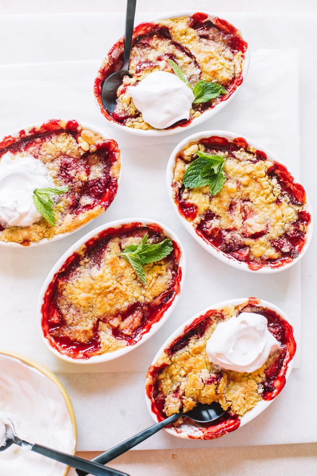 Baked strawberry dump cakes topped with whip cream and mint leaves.