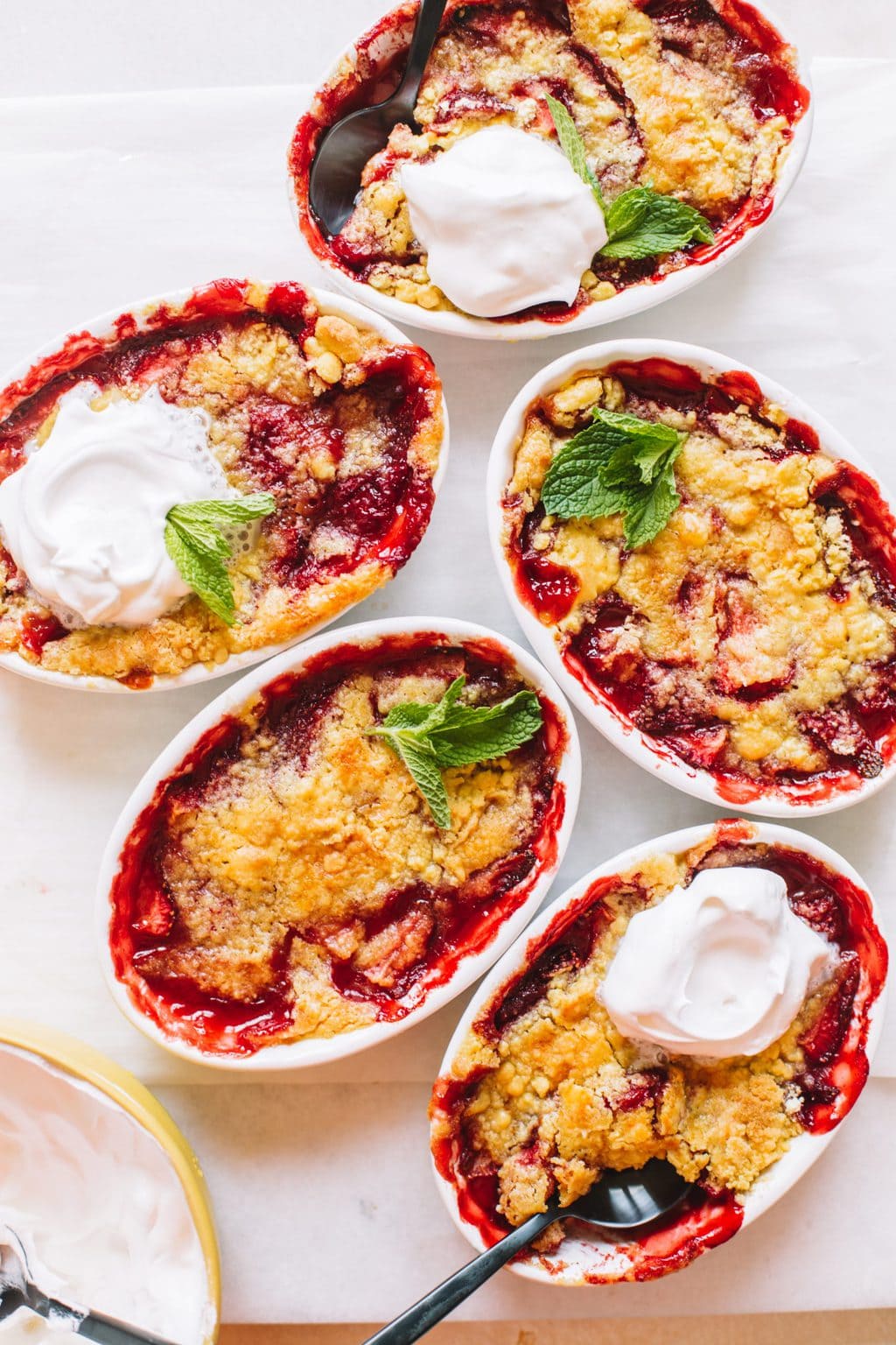 Strawberry dump cakes baked in small white ramekins.