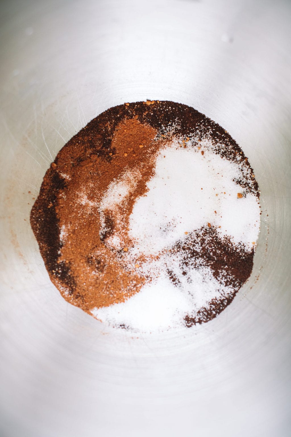 A mixing bowl filled with instant espresso, sugar, and pumpkin spice. 