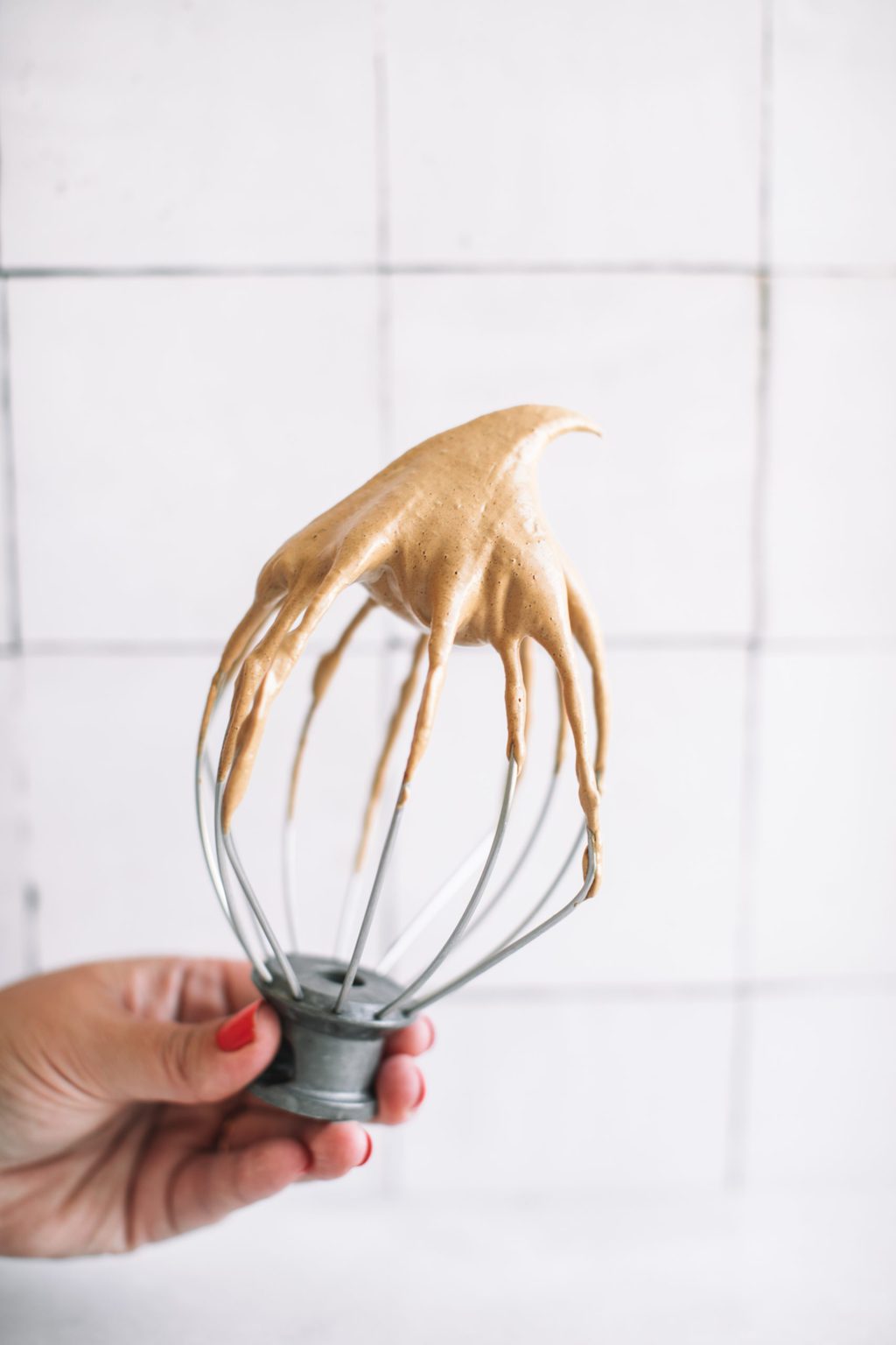 A whisk topped with whipped coffee. 