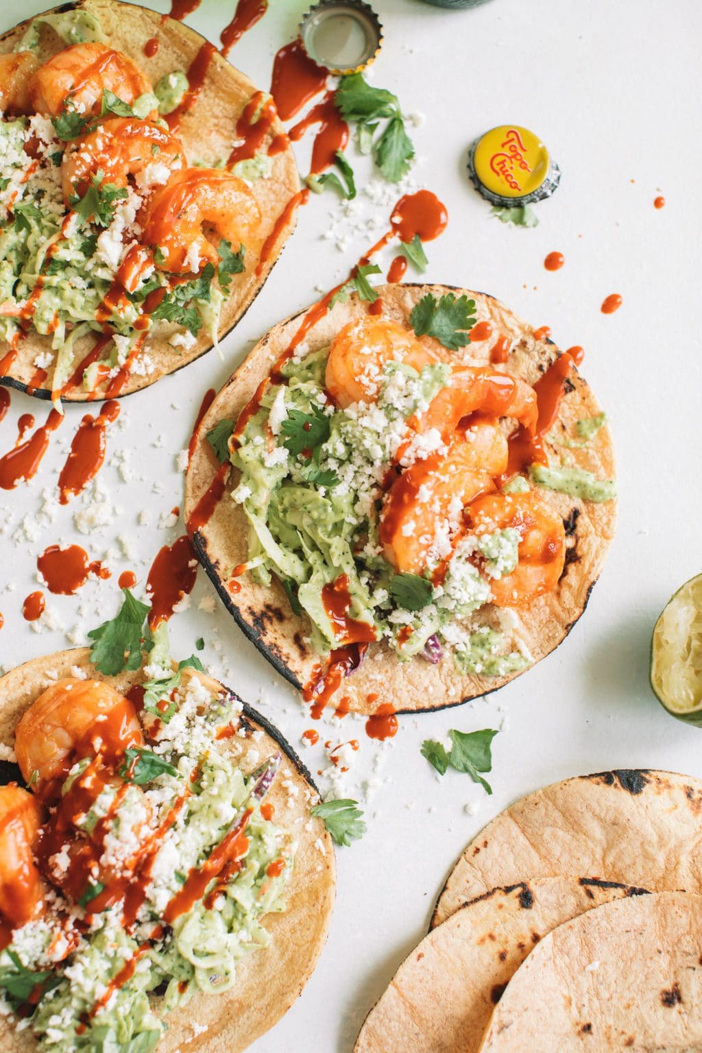 easy shrimp taco recipe with cilantro lime slaw in charred corn tortillas on white surface